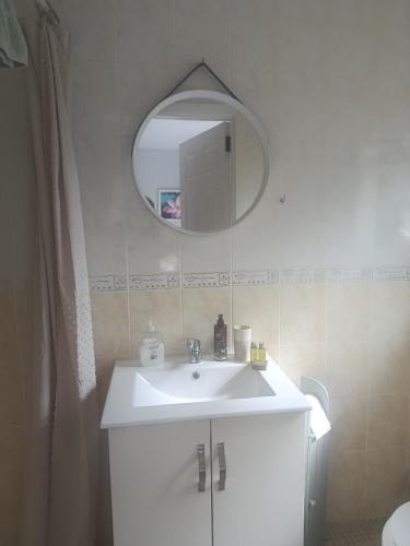 a bathroom with a white sink and a mirror at Cistin Bheag Áine in Ballygawley
