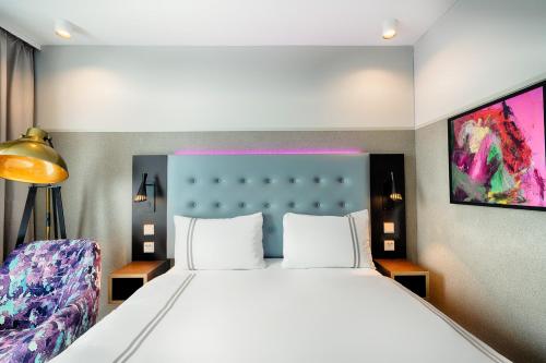 a bedroom with a large white bed and a tv at Premier Inn Wolfsburg City Centre in Wolfsburg