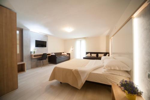 a bedroom with a large bed and a living room at Hotel Ricchi in Rimini