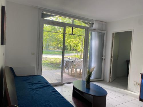a bedroom with a bed and a sliding glass door at Fre&dom in Lacanau