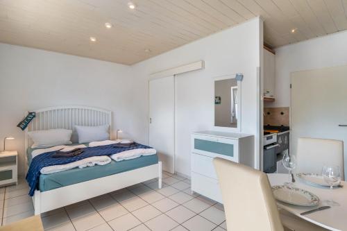 a bedroom with a bed and a table and a kitchen at Haus Achtern Diek - Ferienwohnungen in Wangerland