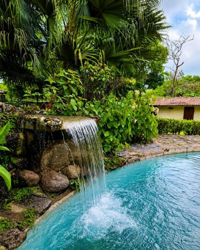 a waterfall in the middle of a swimming pool at Hotel Rincón Vallero in Valle de Anton