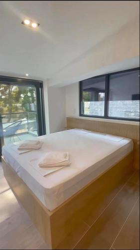 a large bed in a room with a large window at Grey Pearl Apartments in Nea Kallikrateia