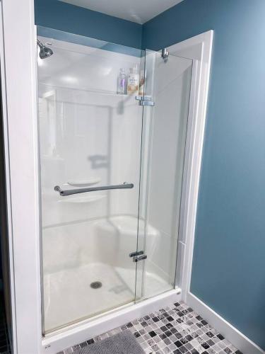 a shower with a glass door in a bathroom at Ocean Pines seaside cottage in Shelburne