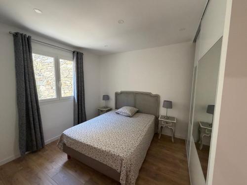 a small bedroom with a bed and a window at Charmant appartement sur les hauteurs d'Erbalunga in Brando
