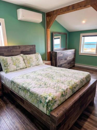 a bedroom with a large bed and a dresser at Ocean Pines seaside cottage in Shelburne