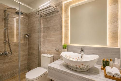 a bathroom with a sink and a shower and a toilet at Lido Corfu Sun Hotel 4 Stars All-inclusive in Benitses