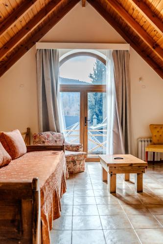 a living room with a bed and a large window at Apart Hotel Agua Escondida in San Martín de los Andes