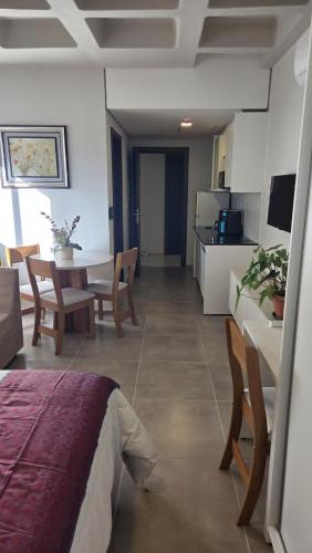 a room with a bed and a table and a kitchen at #5 Monoambiente, Pool, Grill, Gym, Sauna in Nu Guazu