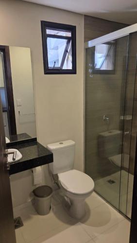 a bathroom with a toilet and a glass shower at #5 Monoambiente, Pool, Grill, Gym, Sauna in Nu Guazu