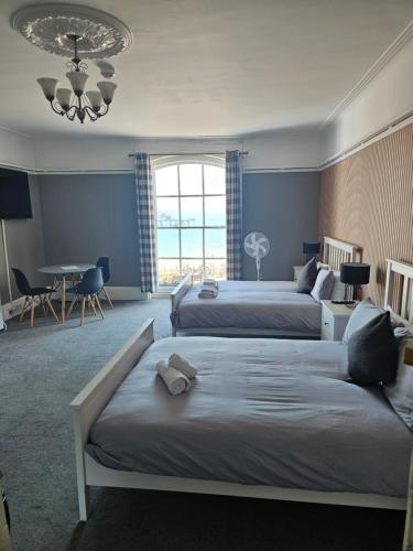 a bedroom with two beds and a dining room with a table at Waterfront Hotel in Deal