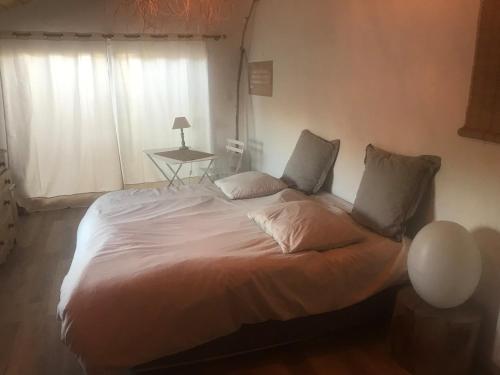 a large bed in a bedroom with a window at Maison au bord de dune et océan in Labenne