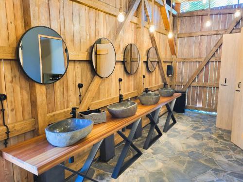 a row of three sinks in a room with mirrors at Resort Oblík - Luxusní stanové městečko in Raná