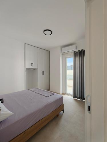 a white bedroom with a bed and a window at DS apartments in Golem