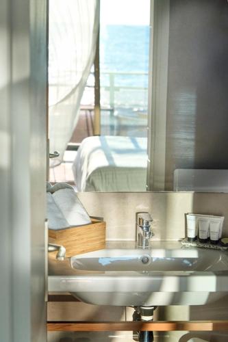 ein Badezimmer mit Waschbecken und Spiegel in der Unterkunft Hotel Plein Large in Bandol