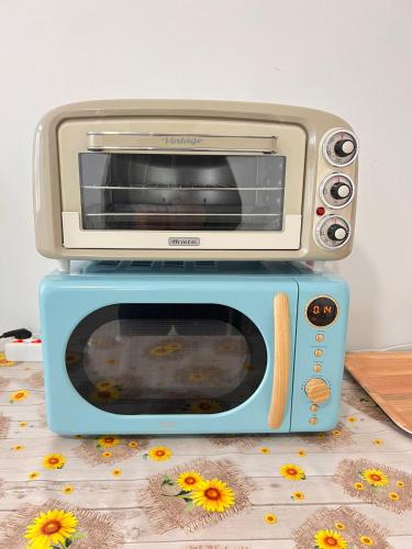 a toaster oven sitting on top of a microwave at Ostello Brebei Niedda - Base Camp Outdoor & View in Gonnesa