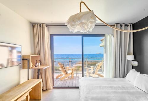 ein Schlafzimmer mit Bett und Meerblick in der Unterkunft Hotel Plein Large in Bandol