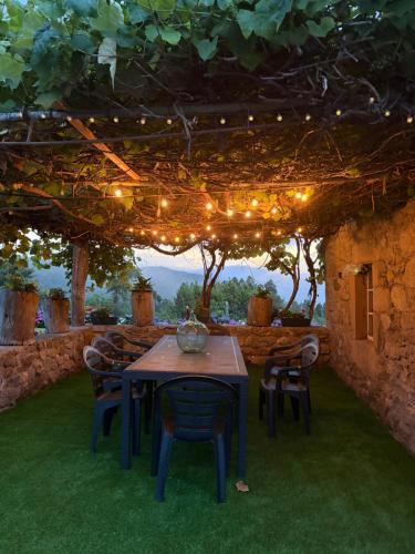 a table and chairs under a pergola with lights at Casa Pereiro playa de Esteiro in Viveiro