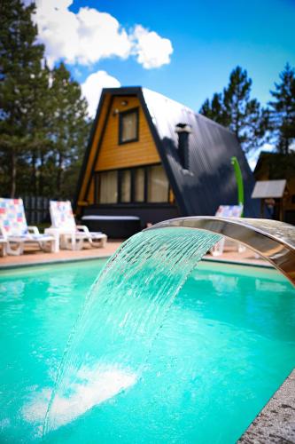 a pool of water with a house in the background at Natural Dream Blidinje in Rudo Polje