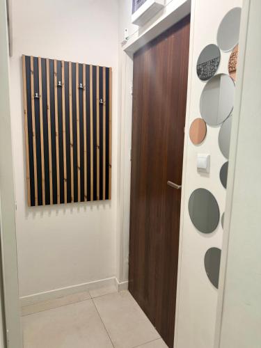 a bathroom with a wooden door and a hallway at Apartament Zielony Gaj Ustroń Wczasowa 90 in Ustroń