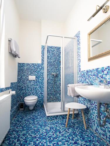 a bathroom with a shower and a toilet and a sink at Die kleine Pension in Delmenhorst