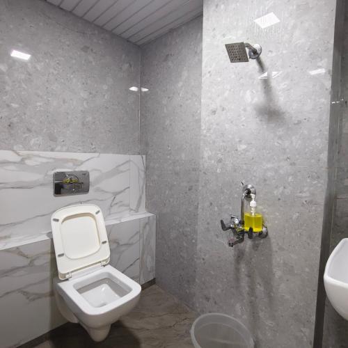 a bathroom with a toilet and a sink at Yash Residency Lodging And Boarding in Ulhāsnagar