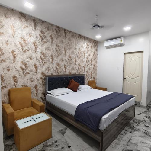 a bedroom with a bed and a chair at Yash Residency Lodging And Boarding in Ulhāsnagar