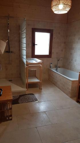 a bathroom with a tub and a sink and a table at Can PUGAT in Bolquere Pyrenees 2000