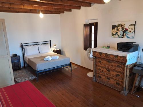 a bedroom with a bed and a dresser in a room at Kissamitakis Guesthouse in Monemvasia