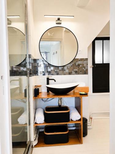 a bathroom with a sink and a mirror at Le cœur de Troyes - Appartement & Studio in Troyes