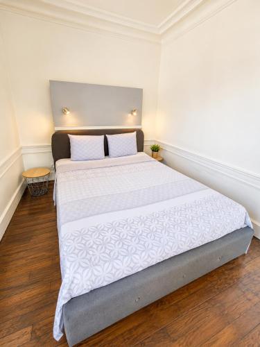 a bedroom with a large bed with white sheets at Le cœur de Troyes - Appartement & Studio in Troyes