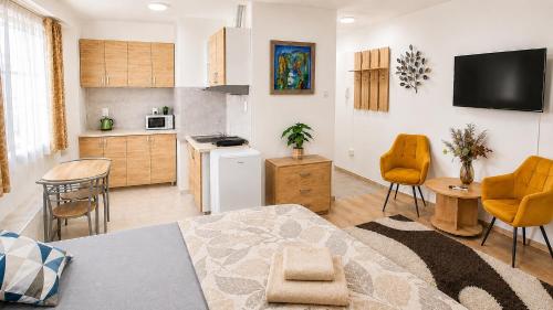 a kitchen and living room with a table and chairs at Clementine Apartman by Flats4You in Százhalombatta