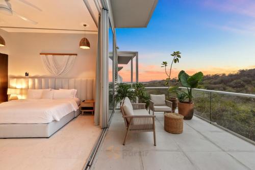 a bedroom with a bed and a balcony at Beachfront Modern Sanctuary - Bolongo in Higuera Blanca
