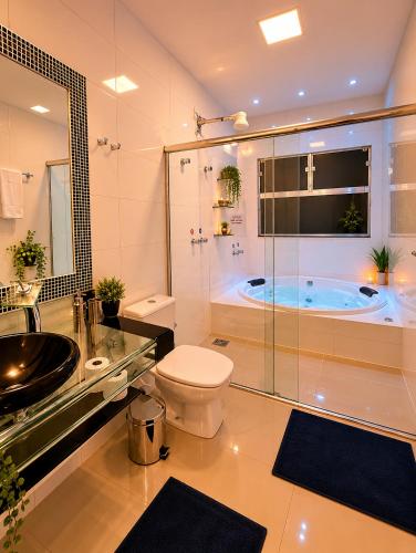 a bathroom with a tub and a toilet and a sink at Pousada Escarpas in Capitólio