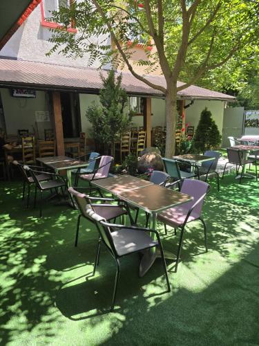 a group of tables and chairs under a tree at Sinziana Eforie Sud in Eforie Sud