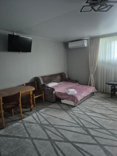 a room with a bed and a couch and a table at Oasis in Edineţ