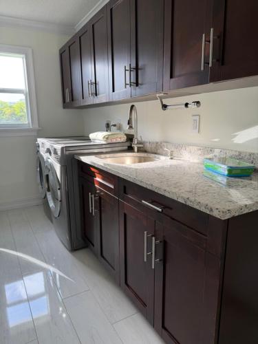 a kitchen with a sink and a washing machine at Regiane Residence in Wellington