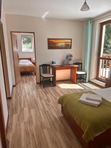 a bedroom with a bed and a desk and a table at U Górala in Cieszków