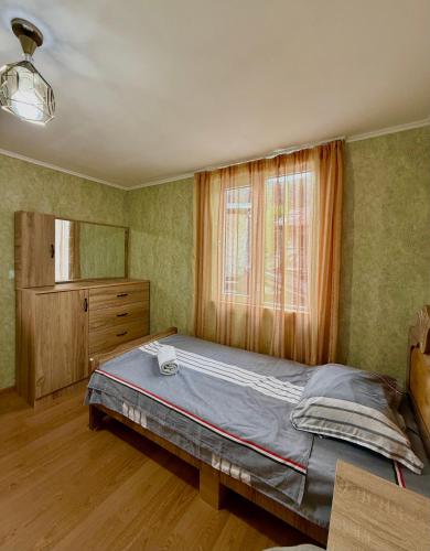 a bedroom with a large bed and a window at Guesthouse Roza in Tsvirmi