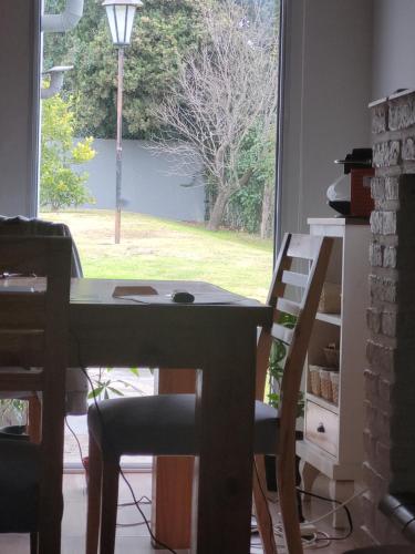 a table and chairs in a room with a window at BAHIA BLANCA-BARRIO PARQUE in Bahía Blanca
