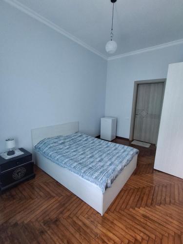 a bedroom with a bed in a room with a wooden floor at Nutsa House in Ts'ikhisdziri