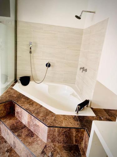 a bath tub in a bathroom with a shower at hotel boutique in Pereira