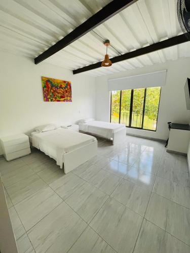 a white room with two beds and a couch at hotel boutique in Pereira