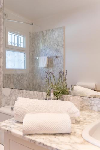 a white bathroom with a sink and a mirror at Villa Can Gavarres in Bell-Lloch