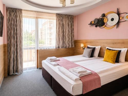 a bedroom with a large bed with a large window at Комплекс Кремен in Blagoevgrad