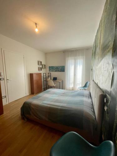 a bedroom with a large bed and a chair at Fabio's Home in Bassano del Grappa
