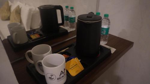 a shelf with two coffee cups and water bottles at Amani Beach Stay in Māvalli