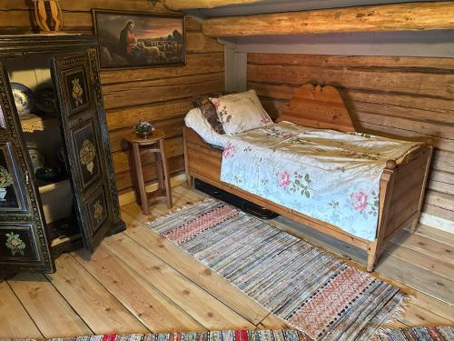 a bedroom with a bed in a room with wooden walls at Härbre Cabin in Årjäng