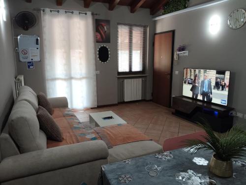 a living room with a couch and a flat screen tv at Casa Maria 3 in Cigole