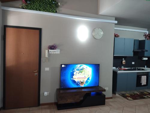 a living room with a flat screen tv next to a kitchen at Casa Maria 3 in Cigole